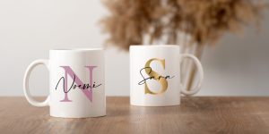 Mockup two white mugs on a wooden table top with pampas decor in a Scandinavian interior, boho style. Template, layout for your design, advertising, logo with copy space. Cups light beige background